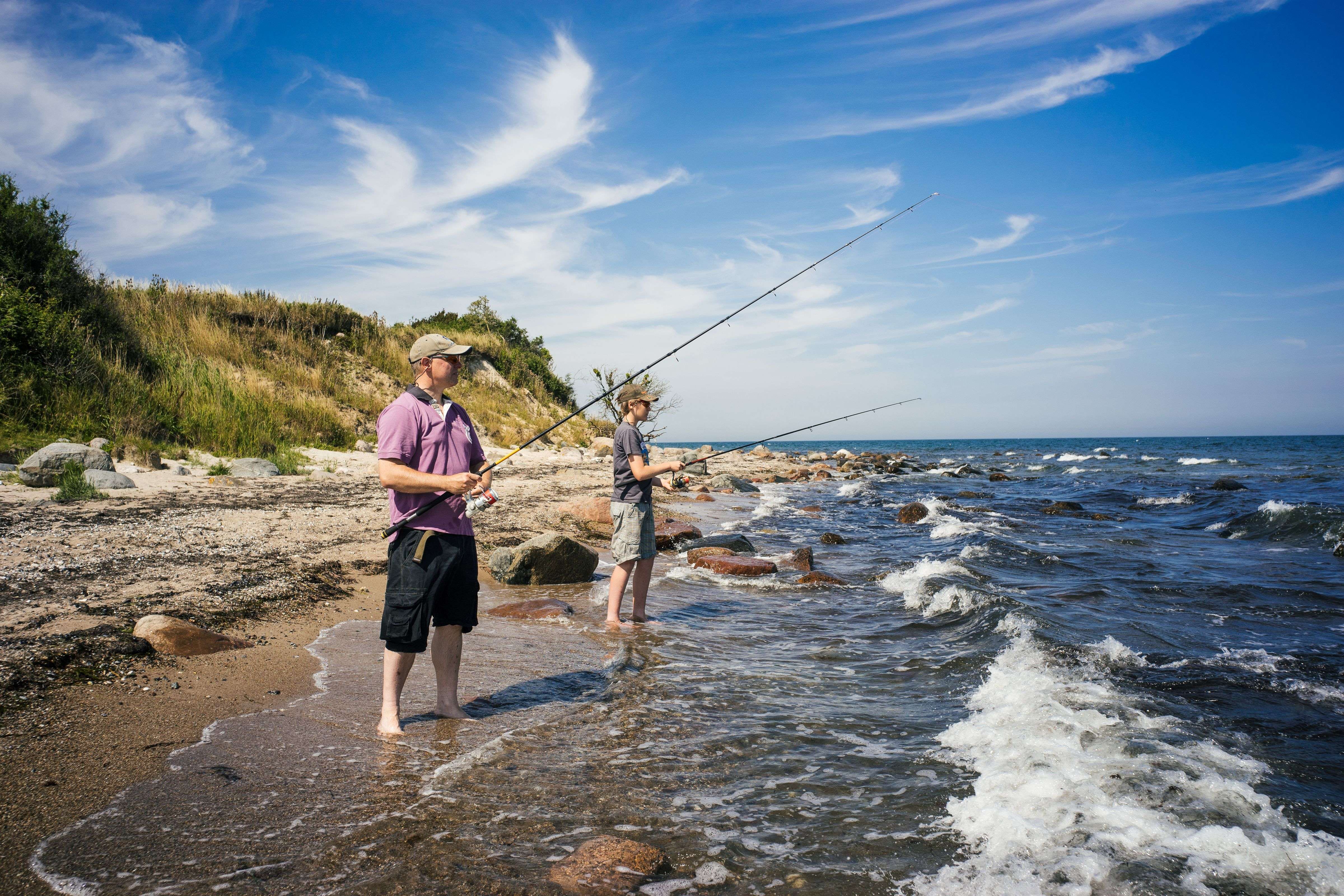 Vater und Sohn angeln im Sommer an der Steilküste