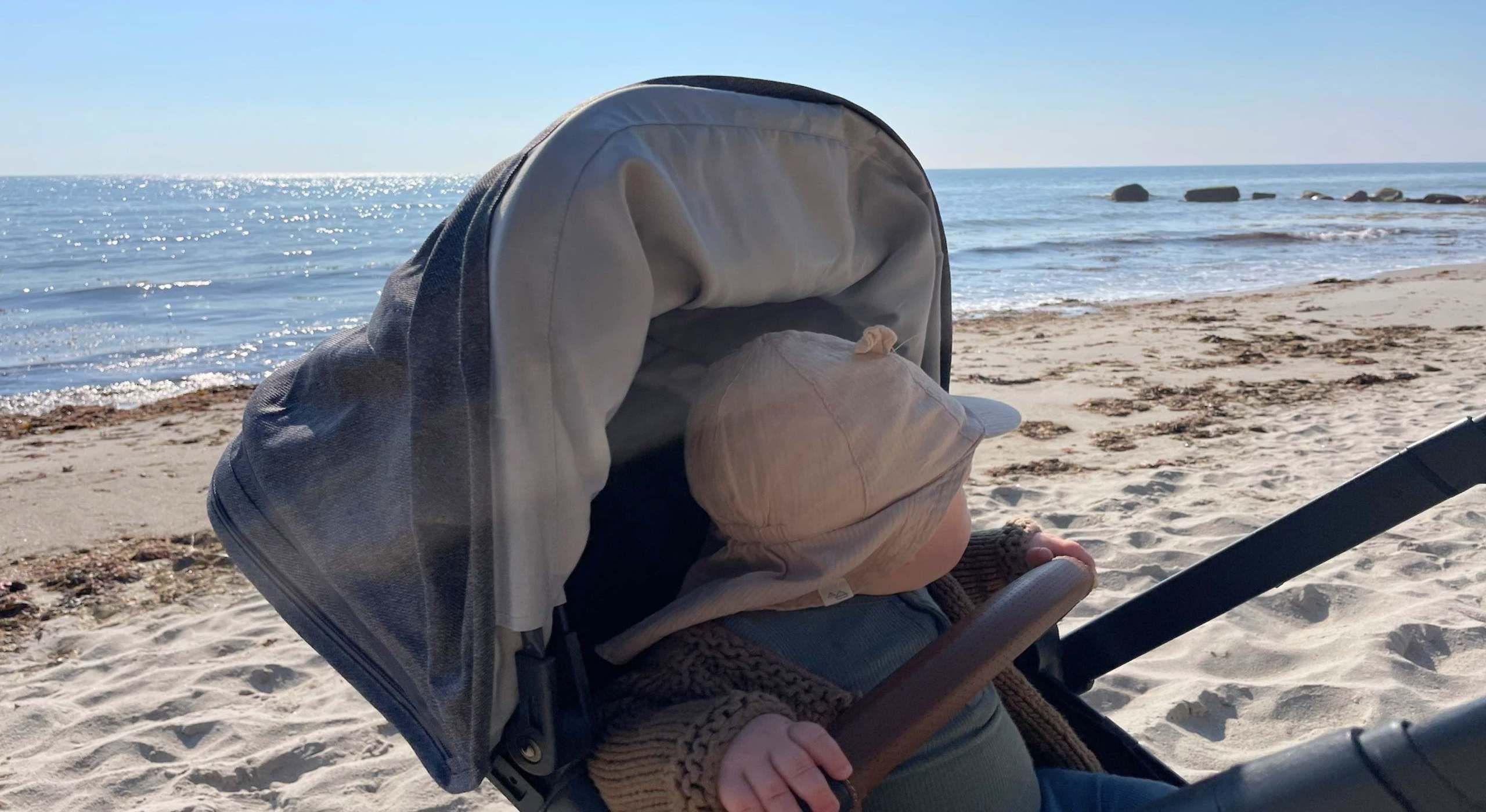 Baby im Kinderwagen am Strand