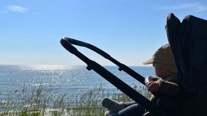 Baby im Kinderwagen mit Blick auf die Ostsee auf Fehmarn