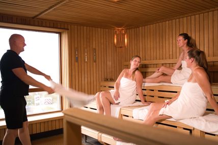 Saunameister Michael Plambeck schwingt ein Handtuch in der Sauna des Fehmare